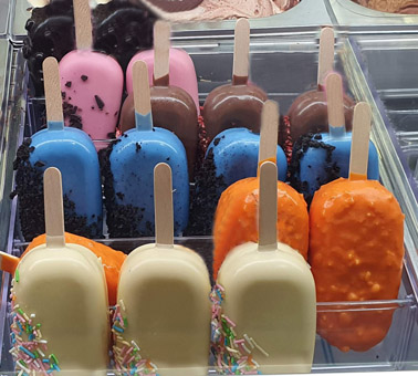 Eisidee bunte Eisschlecker. Eis am Stiel mit buntem Überzug.