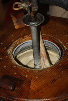 Geschichte der Eiserzeugung. Der Kessel dreht sich, die Holzspachtel bewegt das werdende Speiseeis und schabt es von der Kesselwand ab. Wenn es fertig ist wird es aufgegessen.